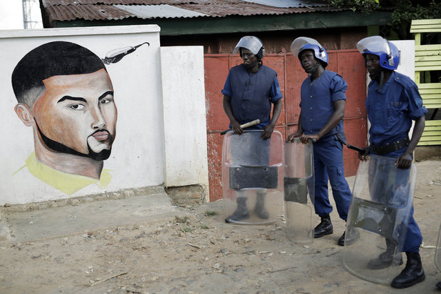 Police stand on patrol as protesters march through the Musaga district of Bujumbura, in Burundi, Monday, May 11, 2015. (Photo by Jerome Delay/AP Photo)