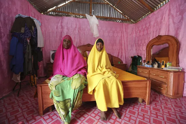 Saciido Sheik Yacquub, 34, poses for a picture with her daughter Faadumo Subeer Mohamed, 13, at their home in Hodan district IDP camp in Mogadishu February 11, 2014. Saciido, who runs a small business, wanted to be a business woman when she was a child. She studied until she was 20. She hopes that Faadumo will become a doctor. Faadumo will finish school in 2017 and hopes to be a doctor when she grows up. (Photo by Feisal Omar/Reuters)