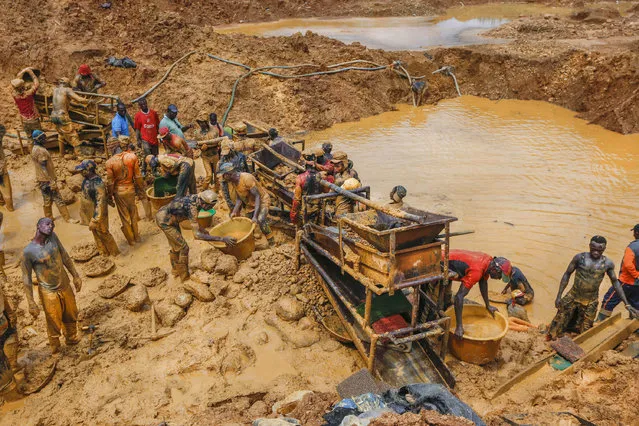 Miners work extremely long days under the hot sun and the hours are often longer in illegal mines in Ghana, West Africa, 2014. (Photo by Heidi Woodman/Barcroft Images)