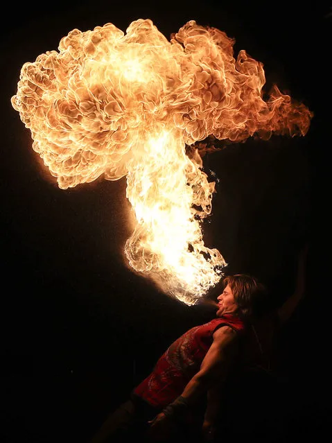 A man breathes out fire during the Phoenix Fire Festival at Lida Castle in Lida, Hrodna Region, Belarus on May 19, 2019. (Photo by Natalia Fedosenko/TASS)