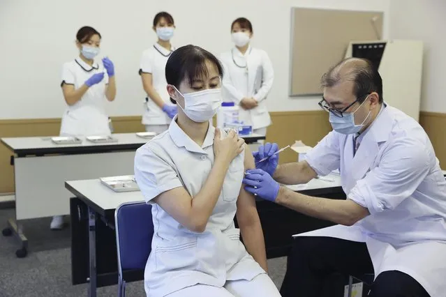 A medical worker of Tokyo Medical Center receives a booster shot of the Pfizer COVID-19 vaccine Wednesday, December 1, 2021 in Tokyo.  Japan has started administering the booster shots to health care workers on Wednesday. (Photo by Kyodo News via AP Photo)