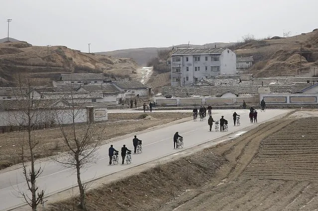 North Korean push their bicycles along a road on Monday, February 22, 2016, in Kaesong, North Korea. In response to the North's recent long-range rocket launch, Seoul shut down a factory park in Kaesong jointly run by both Koreas and this has cost the impoverished North a rare source of legitimate hard currency. (Photo by Wong Maye-E/AP Photo)