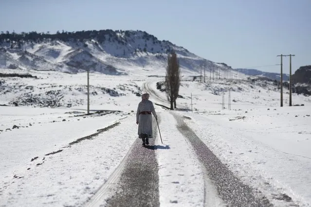 A woman walks home amidst heavy snowfall in the Amazigh Timahdite village, surrounded by snowfall in the Middle Atlas, near Azrou, Morocco, Saturday, December 4, 2021. For the people of the remote Moroccan village of Timahdite, nestled in North Africa's highest mountain range, heavy snowfall brings weeks, or months, of isolation. (Photo by Mosa'ab Elshamy/AP Photo)