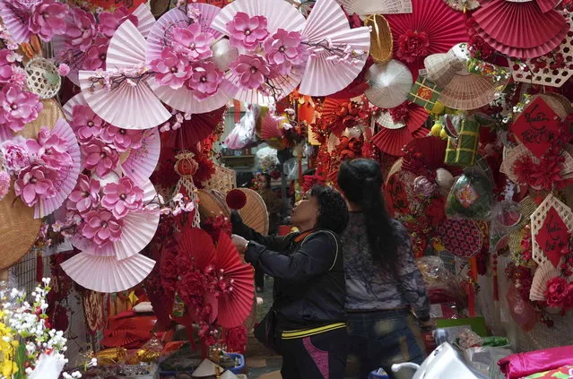 People shop for decorations in a traditional Lunar New Year market in Hanoi, Vietnam Thursday, February 8, 2024. Vietnam is preparing to welcome the Lunar New Year of the Dragon, the most popular festive event of the year. (Photo by Huy Han/AP Photo)