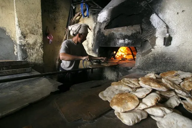 A baker uses firewood amid an acute fuel shortage in Yemen's southwestern city of Taiz May 19, 2015. (Photo by Reuters/Stringer)