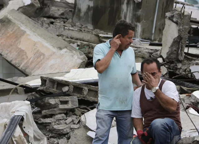Men cry at as they sit amid the debris of their earthquake demolished house in Pedernales, Ecuador, Sunday, April 17, 2016. (Photo by Dolores Ochoa/AP Photo)