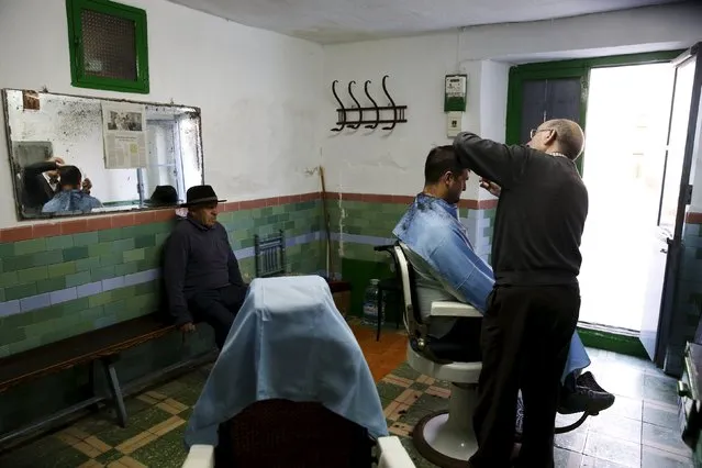 Manolo Carrasco, 75, cuts Juan Francisco Ortega's hair in his family barbershop in the hometown of Don Quixote's ladyship Dulcinea, in El Toboso, Spain, April 6, 2016. “My father had a basin like the one Don Quixote used as a helmet hanging outside the barbershop, but children used to throw rocks at it and he ended up taking it down”, Carrasco says. Now that his father is gone (he worked at the barbershop until 84 and passed away at the age of 95) he keeps it at home. (Photo by Susana Vera/Reuters)