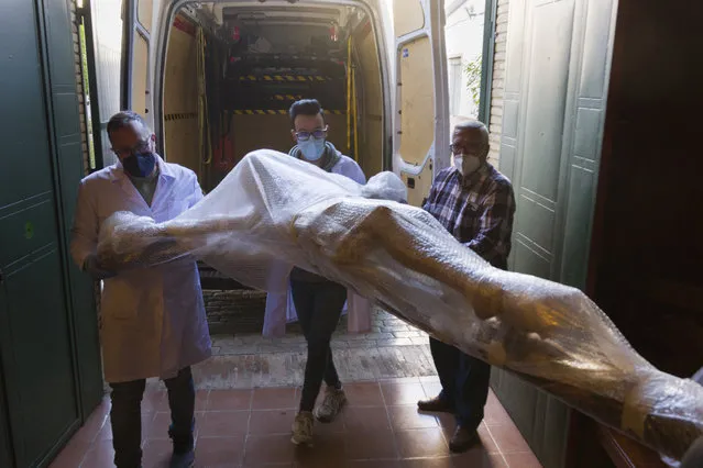 A restored figure of Jesus arrives into Nuestra Senora de la Candelaria church in Seville, southern Spain, Thursday, March 25, 2021. Few Catholics in devout southern Spain would have imagined an April without the pomp and ceremony of Holy Week processions. With the coronavirus pandemic unremitting, they will miss them for a second year. (Photo by Laura Leon/AP Photo)