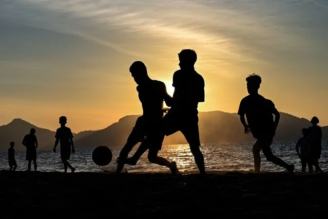 Youths play soccer along a beach as the sun sets in Banda Aceh on January 30, 2022. (Photo by Chaideer Mahyuddin/AFP Photo)