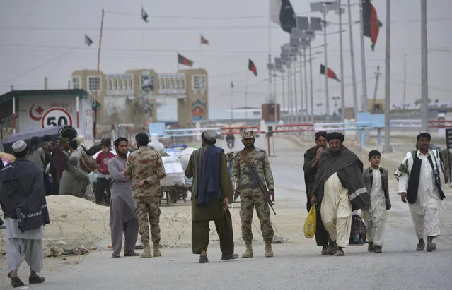 Pakistani paramilitary soldiers stand guard while people wait for opening border crossing, in Chaman, Pakistan, Monday, March 20, 2017. (Photo by Matiullah Achakzai/AP Photo)