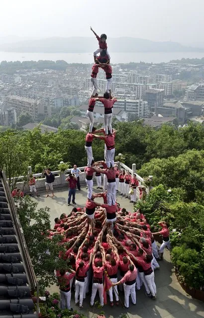 Spanish castellers form a human tower called a “castell” during a performance at the City God Pavilion, or Chenghuang Ge in Mandarin, a tourism resort near the West Lake, in Hangzhou, Zhejiang province, China, July 2, 2015. (Photo by Reuters/Stringer)