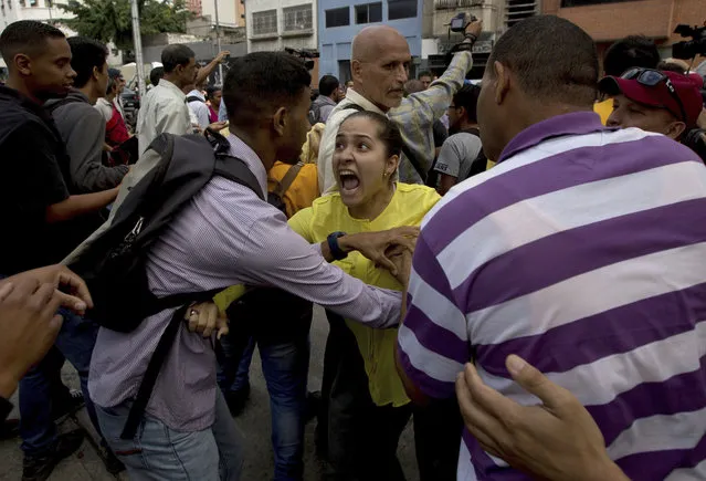 An opposition member, center, argues with a supporter of Venezuela's President Nicolas Maduro during a protest outside of Venezuela's General Prosecutor's office in Caracas, Venezuela, Friday, March 31, 2017. Venezuelans have been thrust into a new round of political turbulence after the government-stacked Supreme Court gutted congress of its last vestiges of power, drawing widespread condemnation from foreign governments and sparking protests in the capital. (Photo by Fernando Llano/AP Photo)