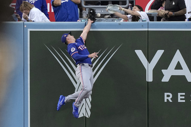 Texas Rangers left fielder Wyatt Langford can't get to a ball hit for a three-run home run by Los Angeles Dodgers' Will Smith during the first inning of a baseball game Tuesday, June 11, 2024, in Los Angeles. (Photo by Mark J. Terrill/AP Photo)