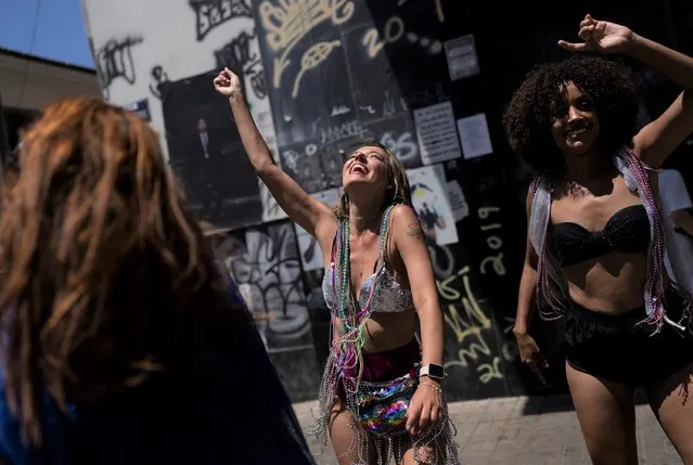Revelers dance during an unofficial carnival block party referred to as “blocos”, in Rio de Janeiro, Brazil, Saturday, February 26, 2022. (Photo by Silvia Izquierdo/AP Photo)
