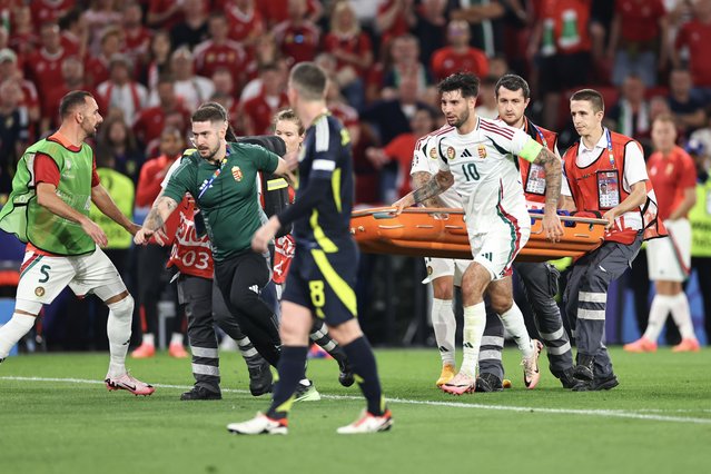 Dominik Szoboszlai of Hungary assists medical staff running on with a stretcher to the injured Barnabas Varga of Hungary during the UEFA EURO 2024 group stage match between Scotland and Hungary at Stuttgart Arena on June 23, 2024 in Stuttgart, Germany.(Photo by Robbie Jay Barratt – AMA/Getty Images)