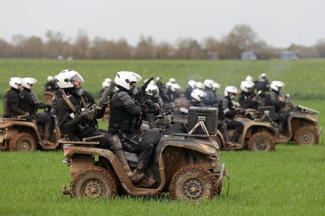 Riot mobile gendarmes, riding quad bikes, fire teargas shells towards protesters during a demonstration called by the collective “Bassines non merci”, the environmental movement “Les Soulevements de la Terre” and the French trade union “Confederation paysanne” to protest against the construction of a new water reserve for agricultural irrigation, in Sainte-Soline, central-western France, on March 25, 2023. More than 3,000 police officers and gendarmes have been mobilised and 1,500 “activists” are expected to take part in the demonstration, around Sainte-Soline. The new protest against the “bassines”, a symbol of tensions over access to water, is taking place under thight surveillance on March 25, 2023 in the Deux-Sevres department. (Photo by Thibaud Moritz/AFP Photo)