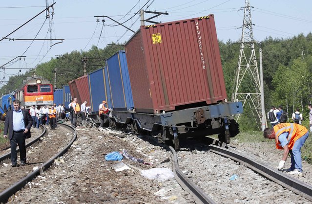 Repair services and Russian Railways employees and investigators gather near the site of a train collision in Moscow region May 20, 2014. A passenger train on its way to Moldova collided with a freight train near Moscow on Tuesday, killing at least four people and injuring 15, a spokeswoman for Russia's Emergencies Ministry said. The reason for the collision, near the town of Naro-Fominsk 55 km (34 miles) southwest of Moscow, was not immediately clear. (Photo by Grigory Dukor/Reuters)