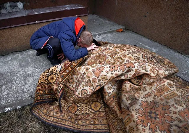 Serhii Lahovskyi, 26, mourns by the body of his friend Ihor Lytvynenko, who according to residents was killed by Russian Soldiers, after they found him beside a building's basement, amid Russia's invasion of Ukraine, in Bucha, Ukraine on April 5, 2022. (Photo by Zohra Bensemra/Reuters)