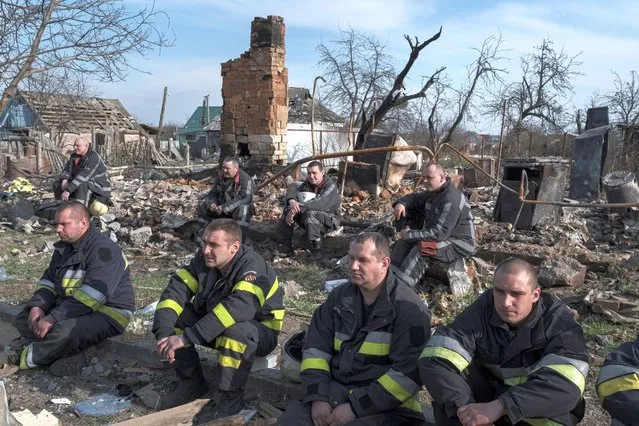 Firefighters take a rest after working at the site of buildings that were destroyed by shelling, amid Russia's invasion of Ukraine in Borodyanka, in the Kyiv region, Ukraine, April 7, 2022. (Photo by Marko Djurica/Reuters)