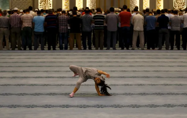 A girl plays as worshippers attend night prayers at Ahmet Hamdi Akseki Mosque in Ankara, Turkey July 14, 2015. (Photo by Umit Bektas/Reuters)