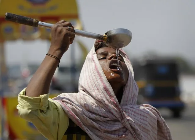 A street vendor drinks water on a hot afternoon on the outskirts of Jammu, India, Friday, May 27, 2016. Temperatures across much of northern and western India have hovered around 40 degrees Celsius (104 degrees Fahrenheit) for weeks causing much distress, specially amongst the farming communities. (Photo by Channi Anand/AP Photo)