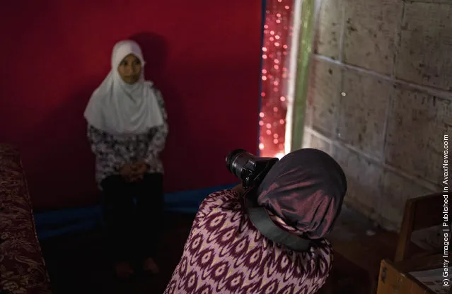 Armless professional photographer Rusidah, 44, takes a customer's portrait