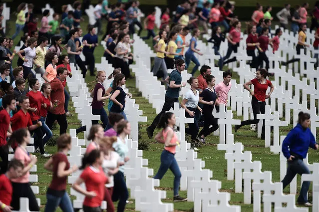 French and German youths take part in a show at the French National cemetery outside the Douaumont Ossuary (Ossuaire de Douaumont), northeastern France, on May 29, 2016, during a remembrance ceremony to mark the centenary of the battle of Verdun. The battle of Verdun, in 1916, was one of the bloodiest episodes of World War I. The offensive which lasted 300 days claimed more than 300,000 lives. (Photo by Frederick Florin/AFP Photo)