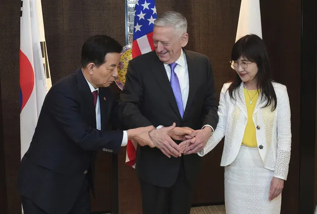 U.S. Defense Secretary Jim Mattis, center, shakes hands with South Korea's Minister of Defense Han Minkoo, left, and Japan's Minister of Defense Tomomi Inada, right, ahead of a trilateral meeting at the 2017 International Institute for Strategic Studies (IISS) Shangri-la Dialogue, an annual defense and security forum in Asia, on Saturday, June 3, 2017 in Singapore. (Photo by Joseph Nair/AP Photo)