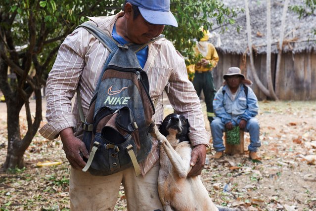 A community member hugs his dog before being evacuated by members of the Armed Forces from the affected areas, while supporting the fight against wildfires in Nuflo de Chavez Province, Bolivia on August 25, 2024. (Photo by Claudia Morales/Reuters)