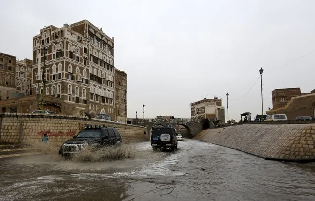 Cars drive in floodwaters during a rainy day in the old quarter of Yemen's capital Sanaa August 1, 2015. (Photo by Khaled Abdullah/Reuters)