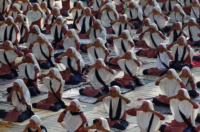 Girls practice yoga during a training session at a school compound ahead of International Yoga Day in Ahmedabad, June 17, 2017. (Photo by Amit Dave/Reuters)