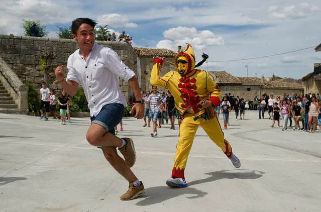 A man representing the devil tries to whip a young boy during the festival of El Salto del Colacho (The devil's jump) on June 22, 2014 in Castrillo de Murcia, Spain. The festival, held on the first Sunday after Corpus Cristi, is a catholic rite of the devil cleansing babies of original sin. (Photo by Denis Doyle/Getty Images)