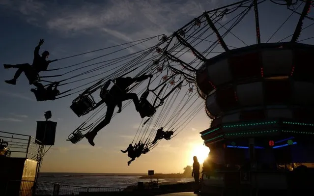 People enjoy a fairground ride in Sanremo, western Italy, on December 14, 2019. (Photo by Valery Hache/AFP Photo)