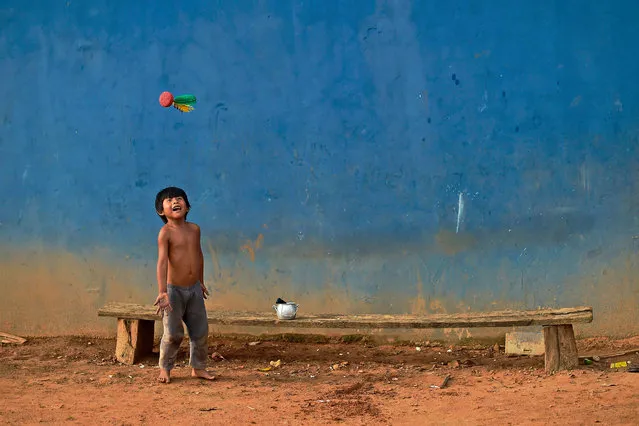 An indigenous boy plays with a Peteca (Shuttlecock) in Piaracu village, near Sao Jose do Xingu, Mato Grosso state, Brazil, on January 16, 2020. Dozens of Amazon indigenous leaders have gathered in the heart of the threatened rainforest to form an alliance against Brazilian President Jair Bolsonaro's environmental policy and his threats to throw their homelands open to mining concerns. (Photo by Carl de Souza/AFP Photo)
