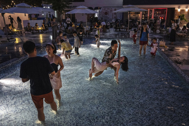 People cool off as they dance in a swimming pool in an event at a local restaurant during a heatwave on July 2, 2023 in Beijing, China. China's capital city and northern parts of the country have experienced unseasonably high temperatures in the last days, sometimes reaching more than 40 degrees celsius, causing local governments to issue heat warnings. (Photo by Kevin Frayer/Getty Images)