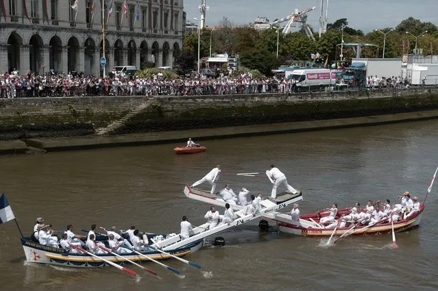 Ships crews take part in the traditional “joutes languedociennes” boat competition on the Nive River in Bayonne, south-western France on July 26, 2017, during the typically Basque Bayonne Festival (Fetes de Bayonne). The 81th Bayonne Festival (Fetes de Bayonne), one of the largest popular events in the world, which receives a million visitors around the festival, includes music, dance, choruses, bullfighting, Basque pelota and other attractions has commenced with enhanced security measures. (Photo by Iroz Gaizka/AFP Photo)