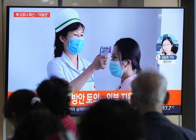 People watch a TV screen showing a news report about the COVID-19 outbreak in North Korea, at a train station in Seoul, South Korea, Saturday, May 14, 2022. North Korea on Saturday reported 21 new deaths and 174,440 more people with fever symptoms as the country scrambles to slow the spread of COVID-19 across its unvaccinated population. (Photo by Ahn Young-joon/AP Photo)