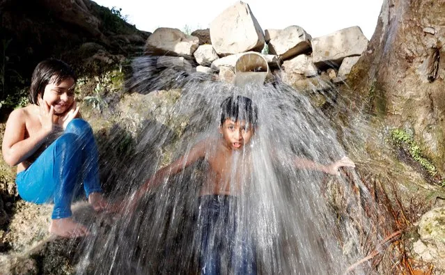 Children cool off in a stream in Islamabad, Pakistan June 14, 2016. (Photo by Caren Firouz/Reuters)