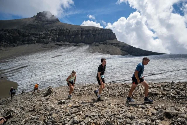 Runners make their way next to the Tsanfleuron Glacier during the last kilometres of the 14th edition of the Glacier 3000 run above Les Diablerets on August 6, 2022. Around 700 runners took part in the 26,2 kilometre-long race starting from the centre of Gstaad and reaching “Glacier 3000” for a total elevation gain of 2015 meters. (Photo by Fabrice Coffrini/AFP Photo)