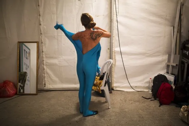 A woman wears her full solid-coloured bodysuit before taking part in a street art performance in Bat Yam, near Tel Aviv, Israel August 29, 2015. Some 40 people participated on Saturday in the performance, initiated by a group of artists called Prizma Ensemble, as part of the city's annual international street art and street theatre festival. The group says the performance deals with concepts of identity and movement in public spaces. (Photo by Amir Cohen/Reuters)