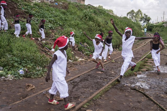 Young dancers run to go and perform at a Christmas ballet event in Kibera slum, one of the busiest neighborhoods of Kenya's capital, Nairobi, Kenya Saturday, December 21, 2024. (Photo by Brian Inganga/AP Photo)