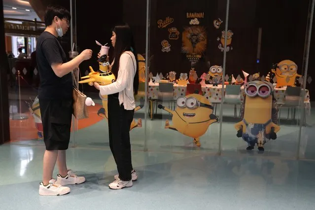 Visitors to a cinema showing the latest Minions: The Rise of Gru movie pass by an event room with the Minions theme in Beijing, Wednesday, August 24, 2022. Chinese viewers of the latest hit Minions movie are getting an added postscript that reinforces a message: Crime doesn't pay.  Foreign films have long been targeted for references to subjects sensitive to the ruling Communist Party, such as Taiwan, the Dalai Lama and human rights. (Photo by Ng Han Guan/AP Photo)
