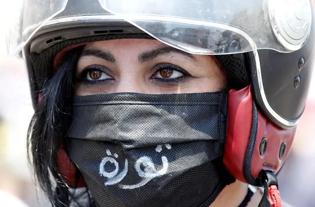 A demonstrator, wearing a mask as a preventive measure against the spread of coronavirus disease (COVID-19), attends a protest against the growing economic hardship and to mark Labour Day in Beirut, Lebanon on May 1, 2020. The word “Revolution” reads on the mask. (Photo by Mohamed Azakir/Reuters)