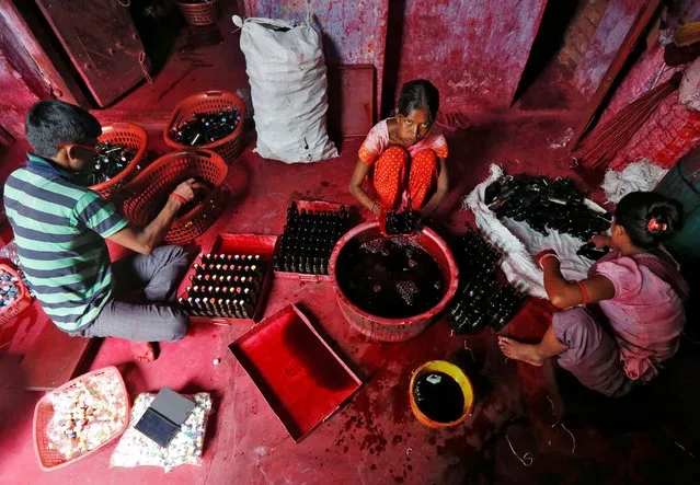 Workers fill bottles with Alta, a red dye which Hindu women apply with cotton on the border of their feet during marriages and religious festivals, at a workshop in Kolkata, India August 2, 2016. (Photo by Rupak De Chowdhuri/Reuters)