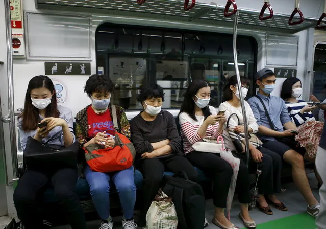 Passengers wearing masks to prevent contracting MERS sit inside a train in Seoul, South Korea, June 5, 2015. (Photo by Kim Hong-Ji/Reuters)