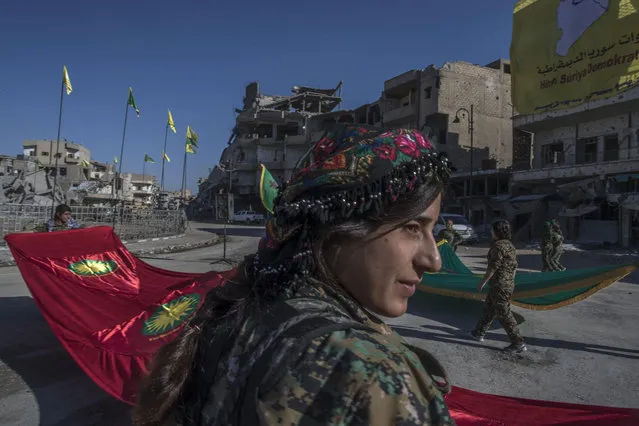 In this Thursday, October 19, 2017 photo, fighters from the Women's Protection Units, or YPJ, hold a celebration in Paradise Square in Raqqa, Syria. The Kurdish female militia that took part in freeing the northern Syrian city of Raqqa from the Islamic State group said on Thursday it will continue the fight to liberate women from the extremists' brutal rule. (Photo by Gabriel Chaim/AP Photo)