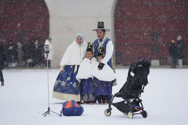A group of family members from Malaysia pose for a selfie in the snow in front of the Gwanghwamun, the main gate of the 14th-century Gyeongbok Palace, one of South Korea's well known landmarks, in Seoul, South Korea, Friday, January 31, 2025. (Photo by Lee Jin-man/AP Photo)