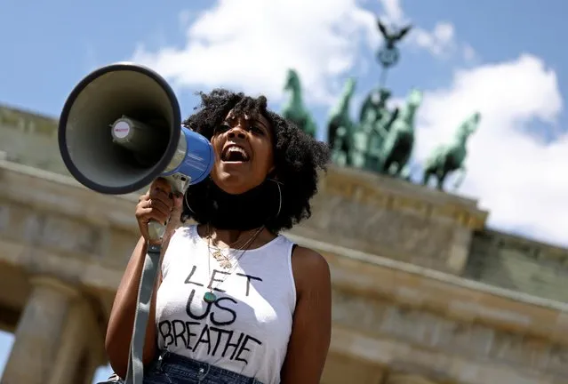 A woman holds a megaphone during a protest against the death in Minneapolis police custody of African-American man George Floyd, at Brandenburg Gate in Berlin, Germany, May 31, 2020. (Photo by Christian Mang/Reuters)