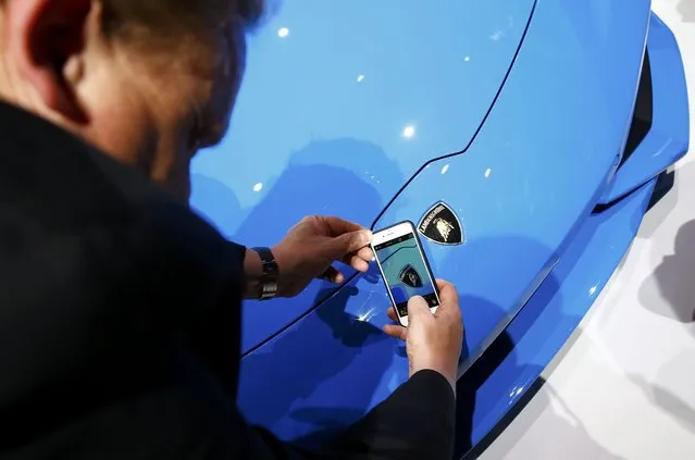 A visitor takes a picture of the logo on the Lamborghini Huracan LP 610-4 Spyder during the Volkswagen group night ahead of the Frankfurt Motor Show (IAA) in Frankfurt, Germany, September 14, 2015. (Photo by Kai Pfaffenbach/Reuters)