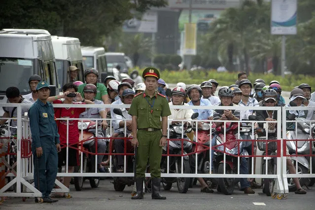 Vietnamese security officials stop traffic along a side street for an official motorcade in Danang, Vietnam, Friday, November 10, 2017, ahead of the arrival of U.S. President Donald Trump to attend the Asia-Pacific Economic Cooperation (APEC) Summit. (Photo by Mark Schiefelbein/AP Photo)